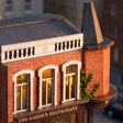 Facade detail: arched windows glowing under the slate turret