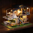 The Giverny Villa glowing at night on a dark walnut shelf