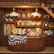 Bakery counter detail: lace cloth, golden scale and bread shelves