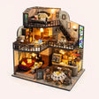 The Grand Cafe DIY miniature roombox kit with LED lights on, studio hero shot