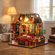 The Lamplight Library on a desk at dusk beside a mug of tea
