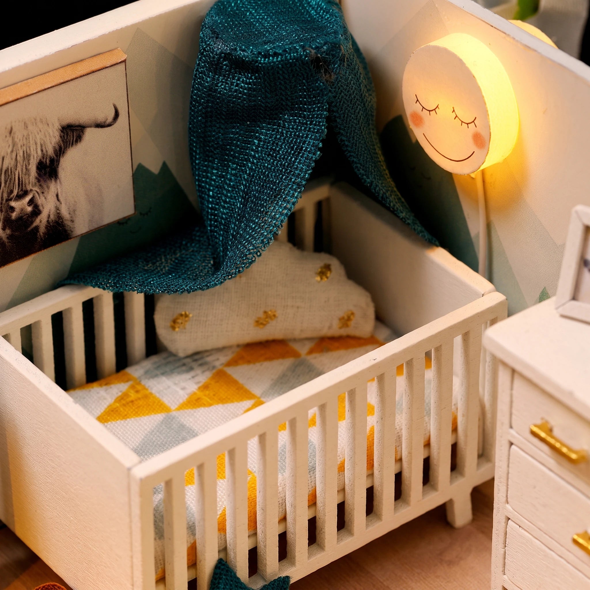 Nursery detail: crib, mermaid blanket and smiling moon lamp