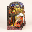 The Midnight Platform DIY book nook kit with LED lights on, on a pale blush background