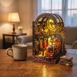 The Midnight Platform book nook glowing on a desk beside a mug of tea