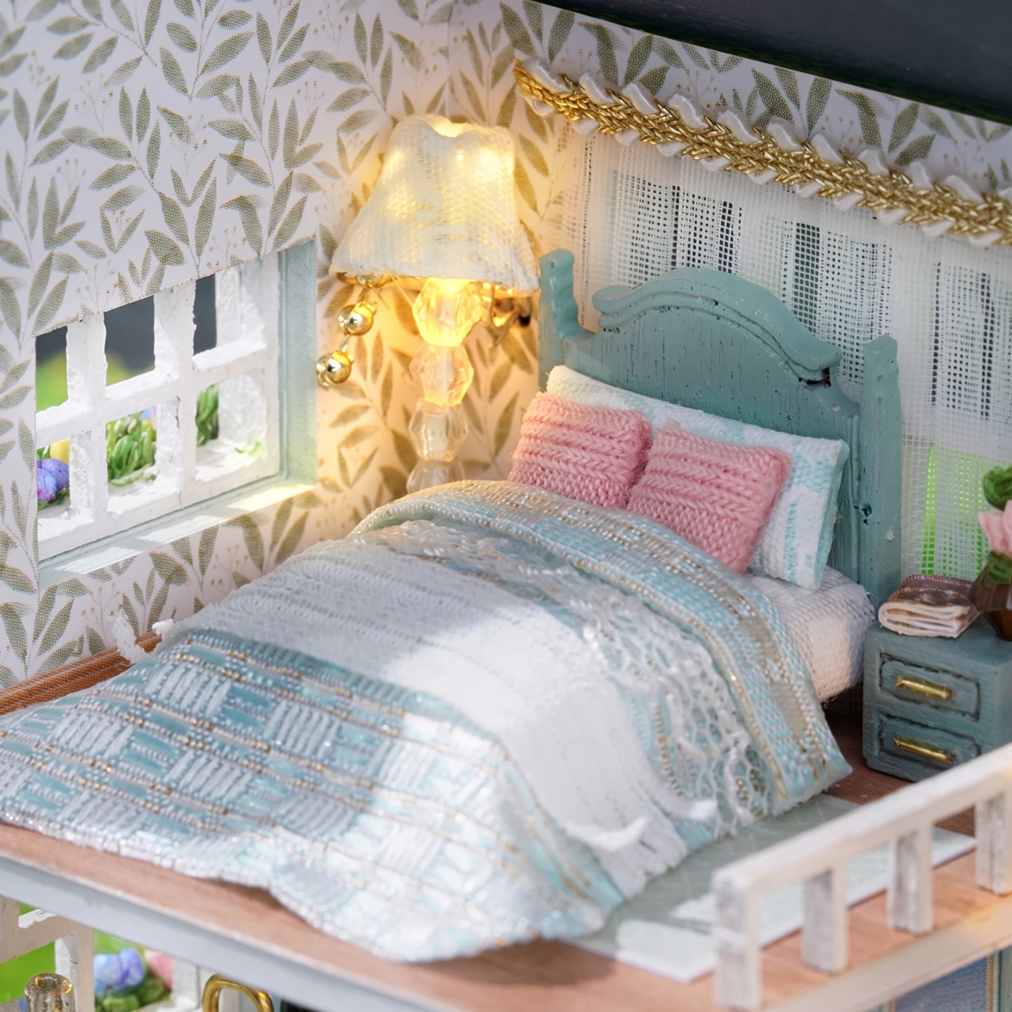 Bedroom detail: seafoam quilt, pink pillows and bedside lamp