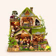 The Mossgrove Cottage DIY miniature kit with LED lights on, studio hero shot