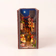 The Night Market book nook kit on a pale blush studio background with LED lights on
