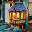 Macro of the lit pavilion among the layered mountains