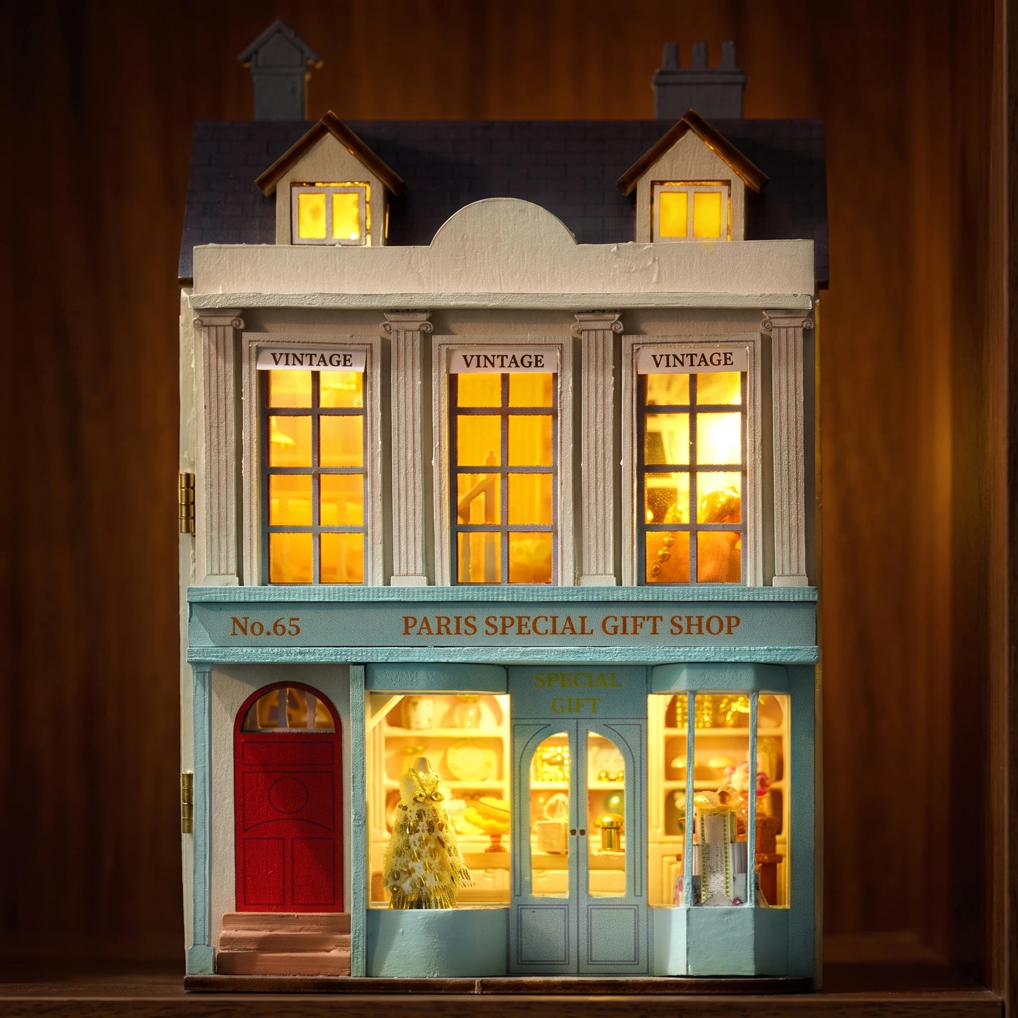The Paris Boutique glowing at night on a dark walnut shelf