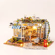 The Pet Club DIY miniature pet shop kit with LED lights glowing on a pale blush studio background