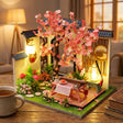 The Petal Courtyard on a desk at dusk beside a mug of tea