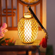 Woven hanging lantern detail with red tassel, glowing