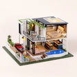 The Poolside Villa DIY miniature kit, LED lit with glowing pool, on a pale blush studio background