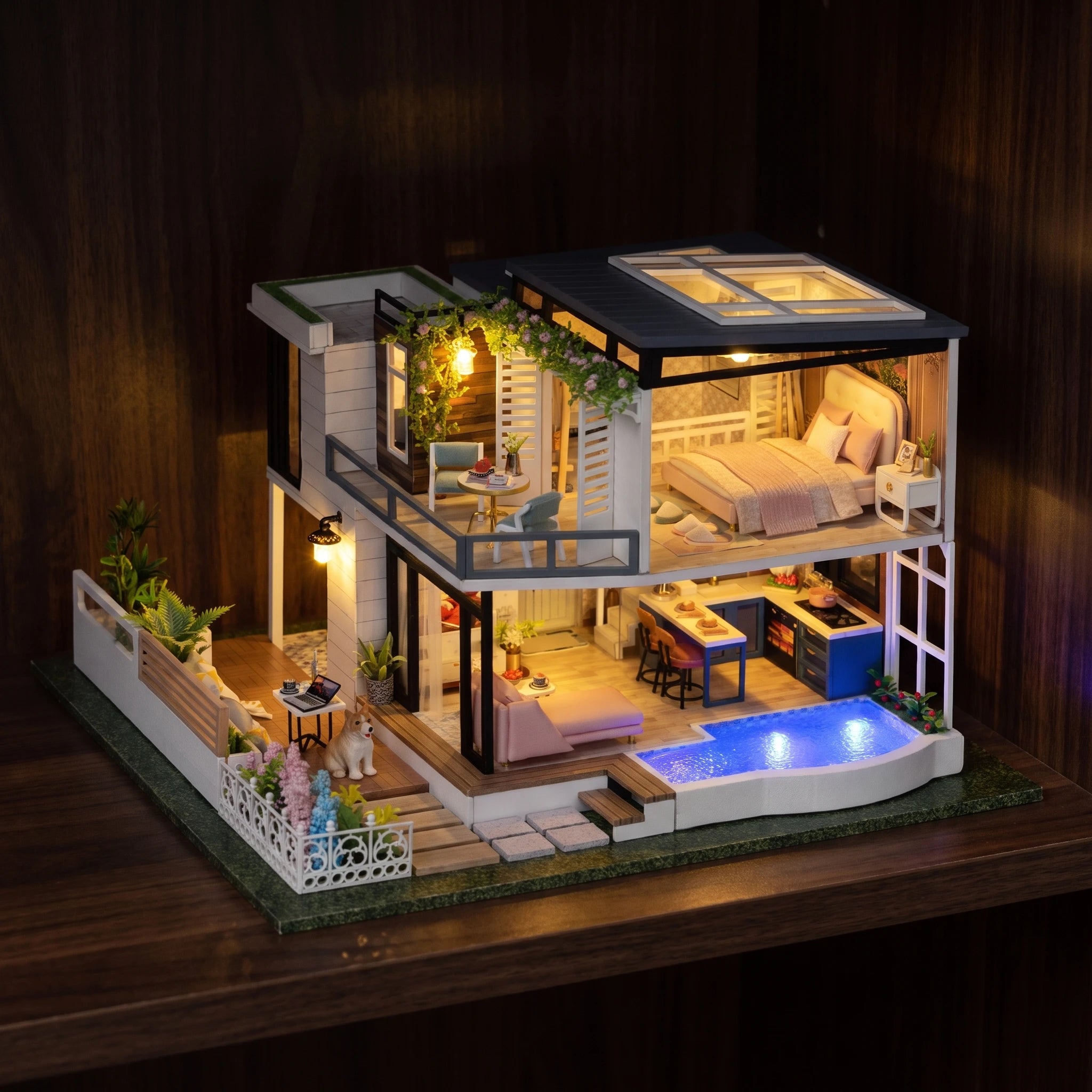 The Poolside Villa glowing at night on a dark walnut shelf