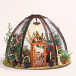 The Seedling Dome DIY miniature glasshouse kit with the hanging bulb glowing, pale blush studio hero