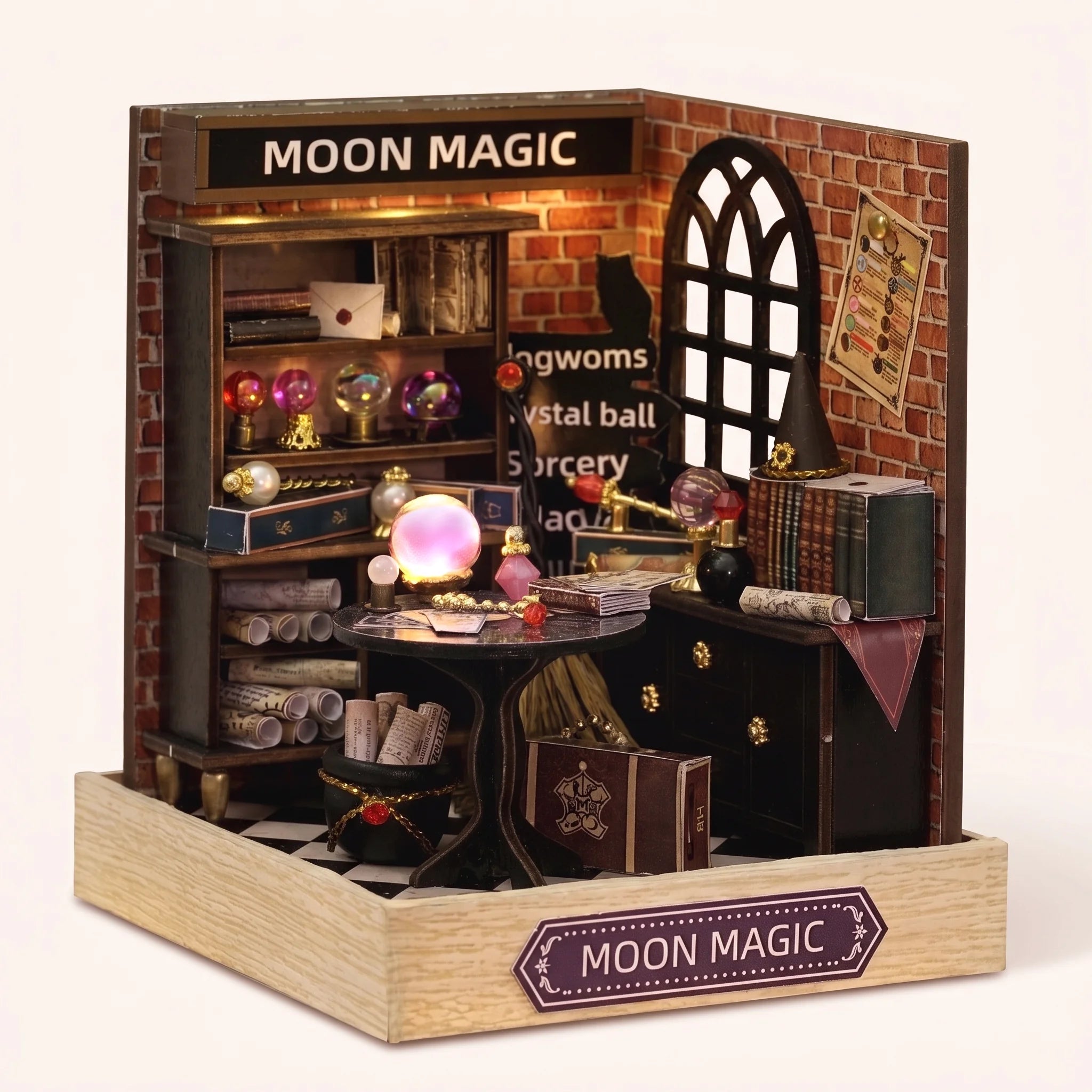 The Seer's Parlor DIY miniature magic kit assembled with the crystal ball glowing, on a pale blush backdrop