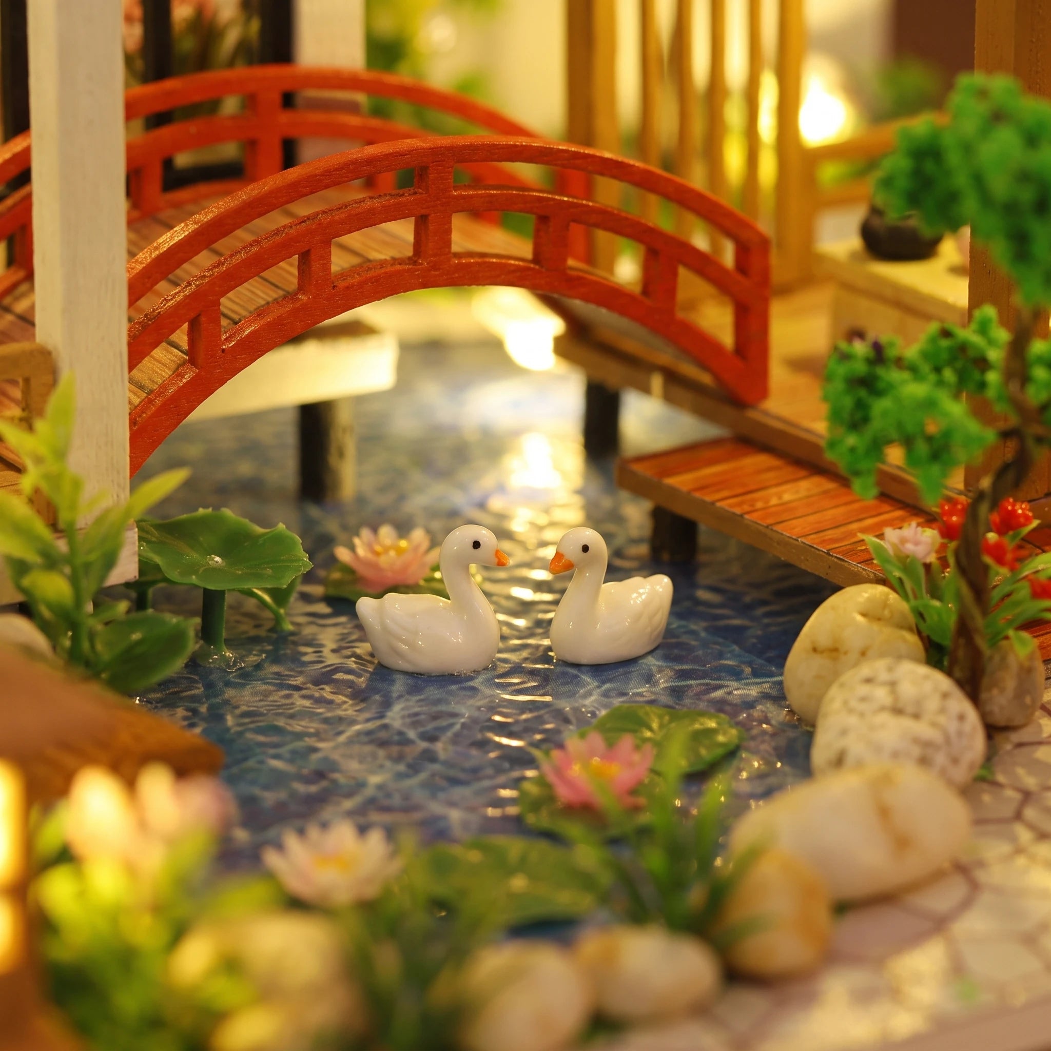 Macro of the koi pond with two swans and the red bridge