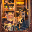 Macro of the shop window with the crystal ball, open spellbook, witch hat and potion shelves