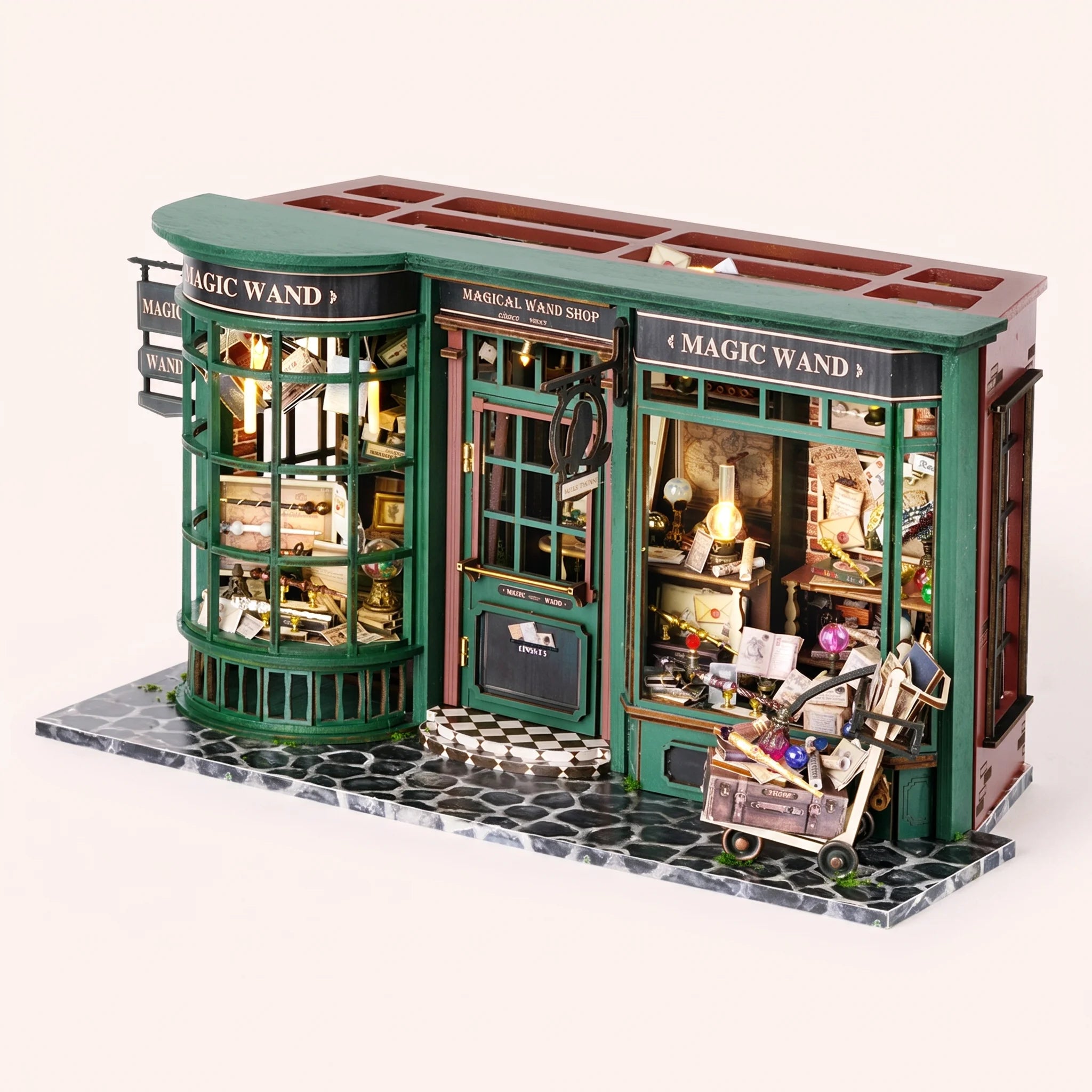 The Wandmaker's Atelier miniature wand shop kit on a pale blush studio background with LED lights on