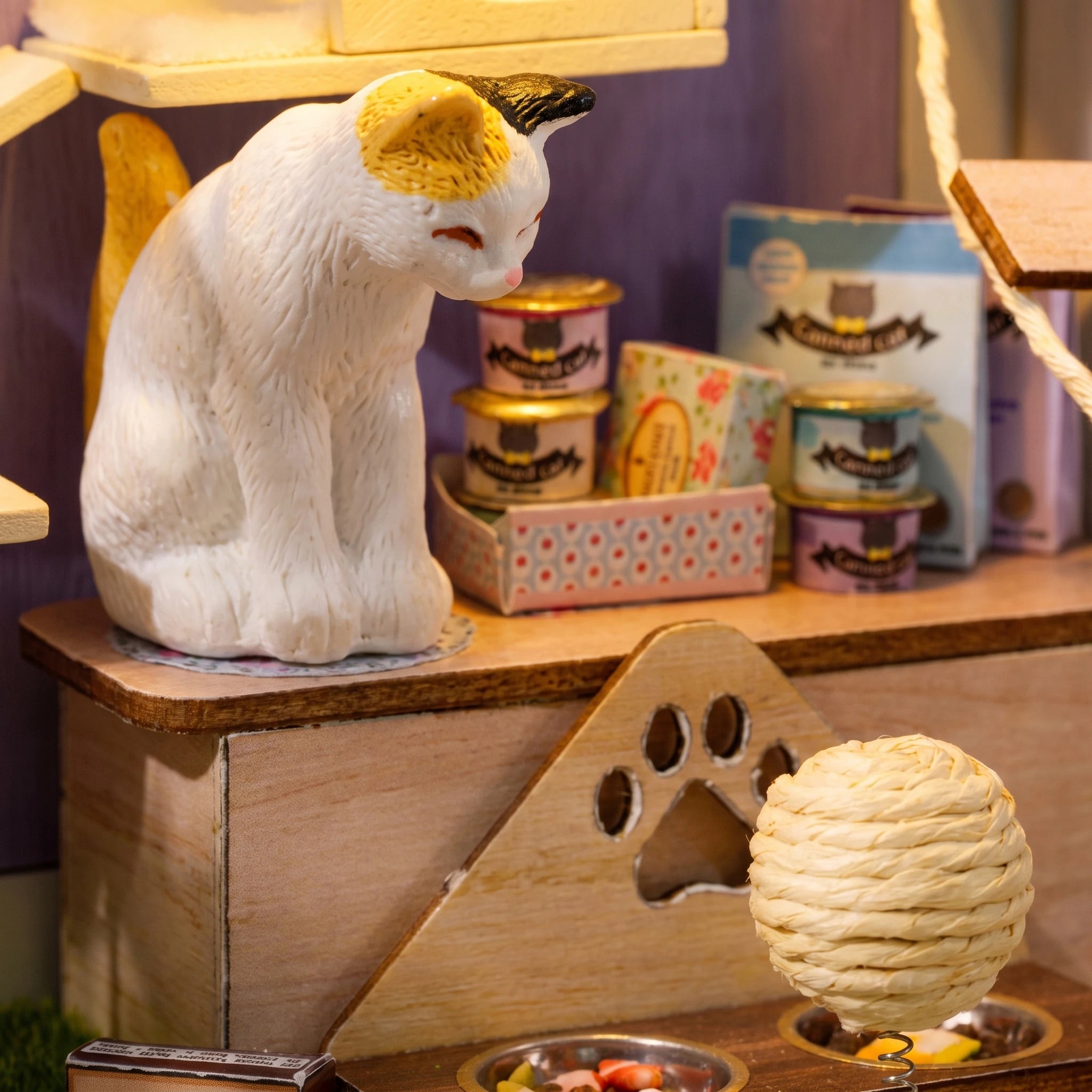 Detail of the calico cat and tiny food tins inside The Whisker Shop
