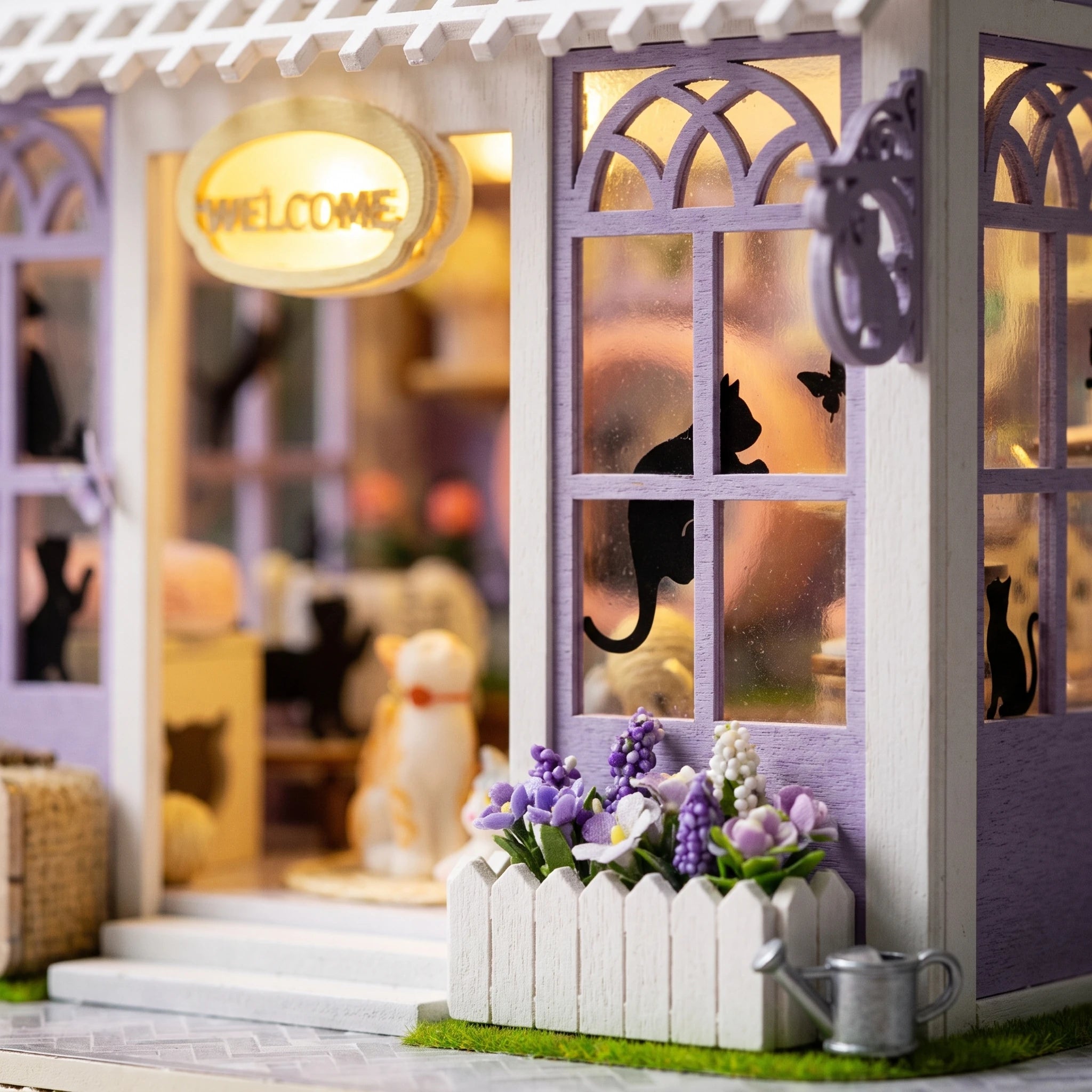 Detail of the glowing welcome sign and flower boxes on The Whisker Shop front