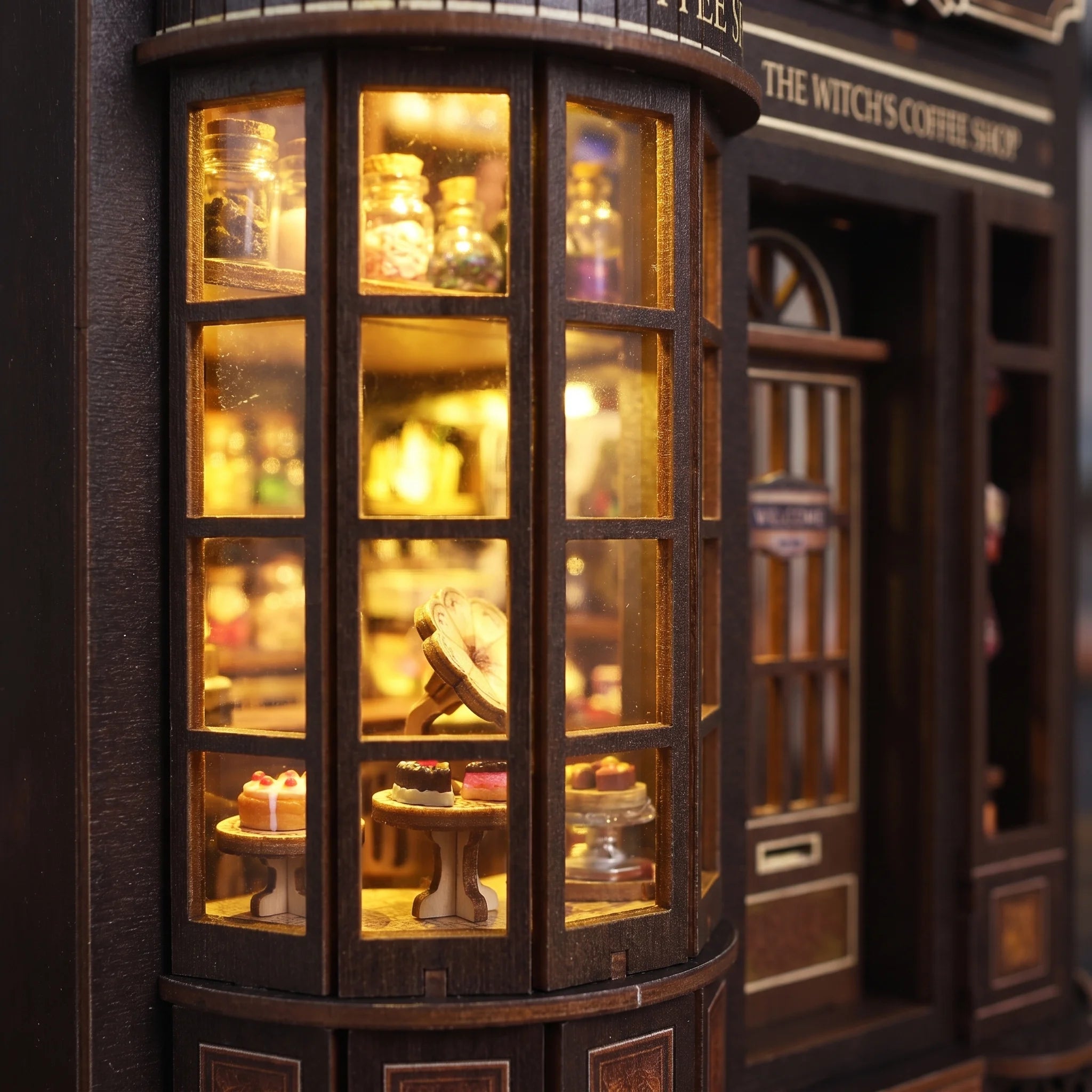 Close up of the curved cake display window of The Witch's Brew book nook