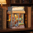 The Tiki Bar kiosk glowing warm between books on a walnut shelf at dusk