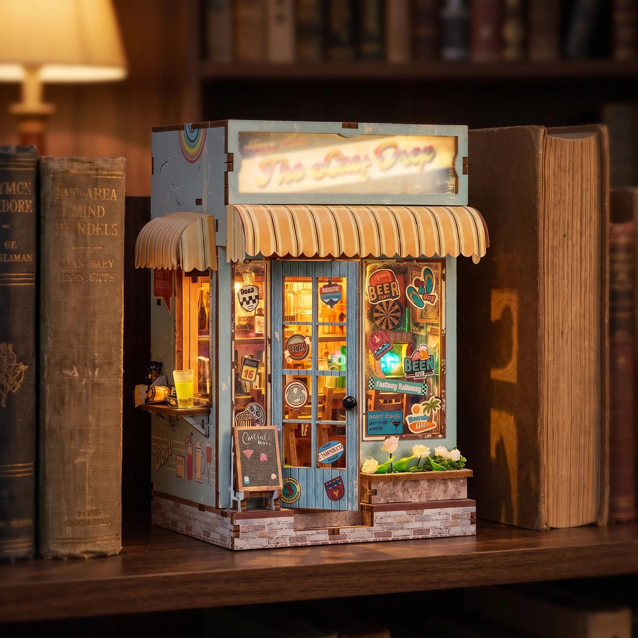 The Tiki Bar kiosk glowing warm between books on a walnut shelf at dusk