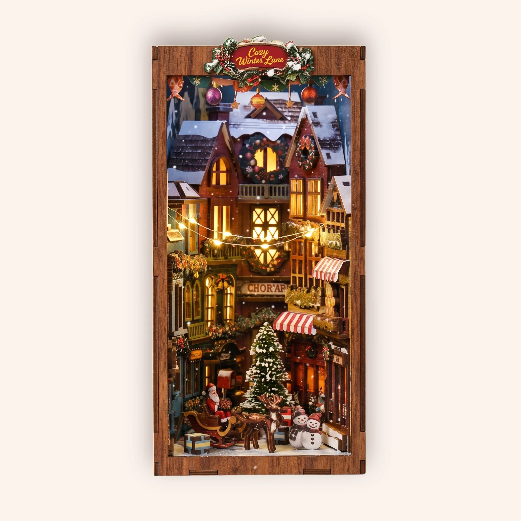 The Winter Lane DIY Christmas village book nook kit, lit, on a cream studio background